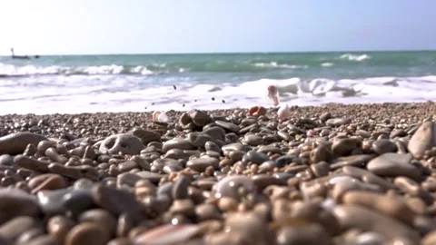 Stones fall into the frame in slow motion sea blurred in the background 스톡 동영상 208042038