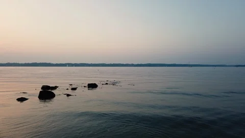 Stones at the ocean. Romantic Sunset with reflection on the water Stock Footage 114971525