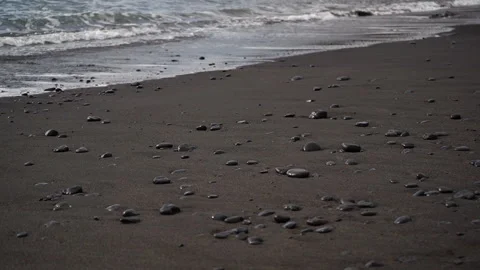 Stones pebble laying down on the sandy beach in the water waves and ocean foam Stock Footage 145617068