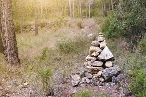 Stones piled up forming a mound at the side of the road. Stock Photos