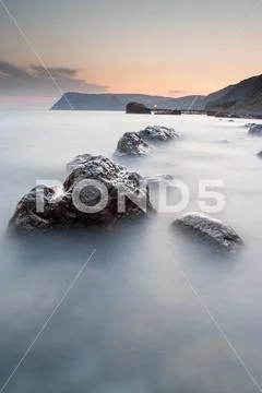 Stones in the sea on a long exposure Stock Photos