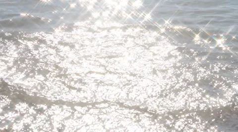 Stones thrown into the water creates additional wave in the solar glare Stock-Footage 61656964