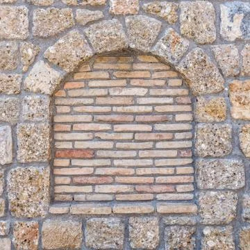 Stonewall with arch frame shape and brickwork, textured pattern background Foto stock