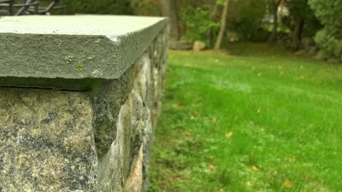 Stonewall with bluestone top in backyard cam left blur background Stock Footage 140886926