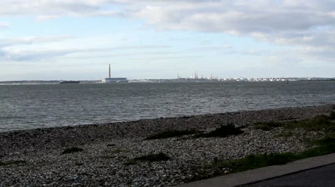 Stoney beach at Lee on Solent view towards Fawley Power Station &amp; Oil Refinery Stock Footage 45593407