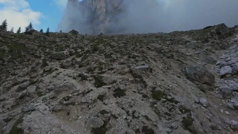 Stony alpine plateau beneath towering peak, geologist survey on rocky moraine Stock Footage 325825472