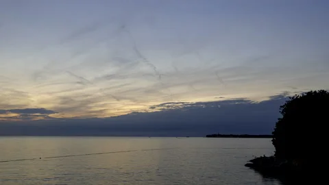 Stony beach with city while cloudy sunset and dusk and city at coast time lapse Stock Footage 209261185