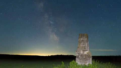 Stony monument among green fields under starry sky with milky way Stock Footage 165349736
