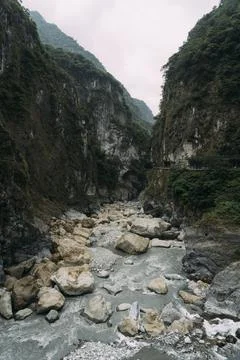 Stony river bed with epic steep cliffs on each side in Taroko National Park. Stock Photos