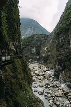 Stony river bed with steep cliffs on each side in Taroko National Park. Stock Photos