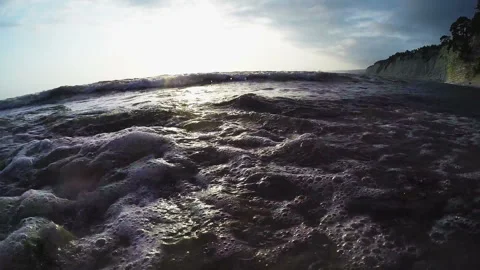Stony seashore at sunset with sun highlights on the rocks Stock Footage 104512103