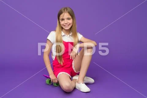 Stop and relax. Kid girl relax sits penny board. Modern youth hobby. Girl happy Stock Photos