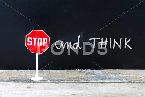 STOP and THINK message written on chalkboard Stock Photos