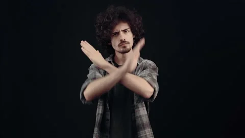 Stop. The annoyed young man extends his palm forward, the stop sign, he says no Video stock 154314856
