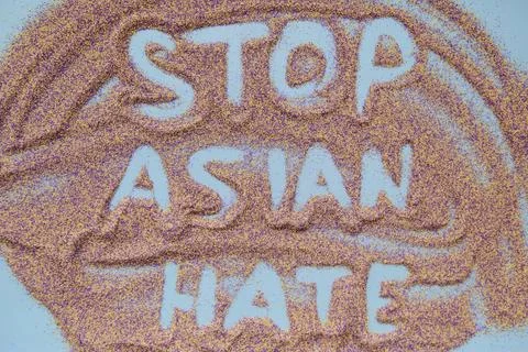 Stop asian hate text handwritten on colorful sand. Actual problem Stock Photos
