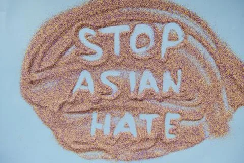 Stop asian hate text handwritten on colorful sand. Actual problem Stock Photos