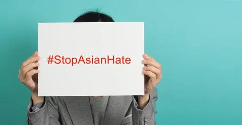 Stop asian hate write in white board paper.Asian Woman holding paper on green Stock Photos