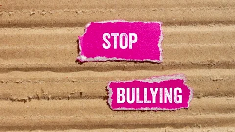 Stop bullying message writing on ripped torn pink paper pieces on cardboard.. Stock Footage 299565407