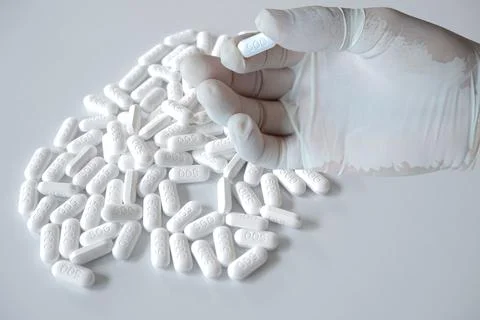 Stop commenting that it's addictive. human hand on white pill background on e Stock Photos