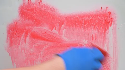 Stop coronavirus concept. hand in blue rubber glove washes glass from red paint 库存影片 128807763
