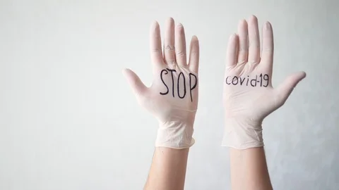 Stop covid-19 text on white medical gloves. A protective agent against Stock Footage 126970784