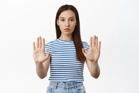 Stop, final warning. Young concerned woman extend hands, stretch out palms in Stock Photos
