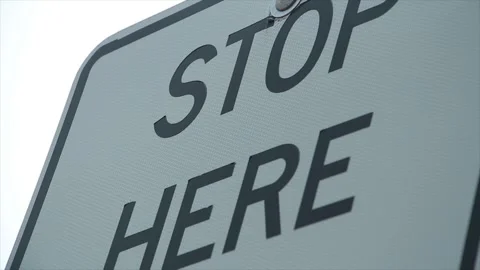Stop here caption writing text metal sign blowing and shaking from wind, black Stock Footage 247143886