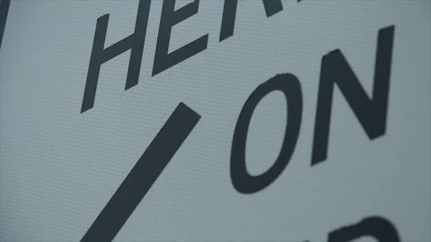 Stop here on red light signal caption writing text metal sign, black capitals Stock Footage 247143897