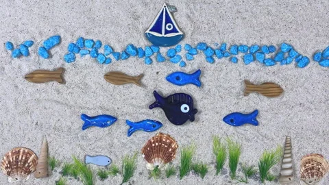 Stop Motion Animation of a Blue Boat and Swimming Fish on Sand Video stock 326165059