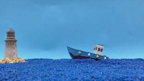 Stop Motion Animation of a Blue Boat and Lighthouse on a Blue Stone Sea Stock Footage 326196404