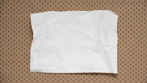 Stop motion animation of crumpled paper on a brown polka dot background Stock Footage 336077314