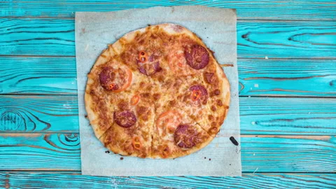 Stop motion animation of eating pizza on baking paper on blue wooden backgrou Stock Footage 151130409