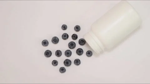 Stop motion animation Fresh berries vs pills. Blueberries go in the jar. Stock Footage 212314847