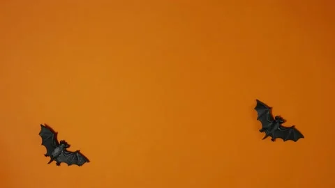 Stop motion animation halloween decor flying bats on orange background. Trick Stock Footage 188877326