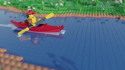 Stop motion animation of Lego minifigure paddles down a river in a kayak. Stock Footage 250504534