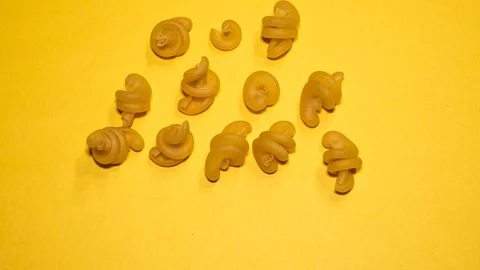 Stop-motion animation of moving pasta over yellow background. Stock Footage 129451189