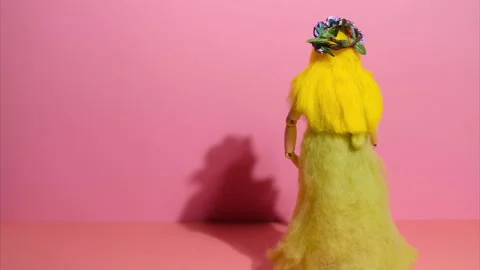 Stop motion animation, moving wooden doll made of felt. Female doll with long Stock Footage 232378712
