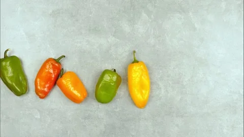 Stop motion animation with  multicolor pepper on a grey background Stock Footage 137058169