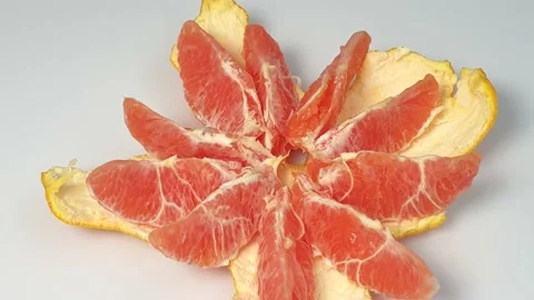 Stop motion animation of peeling a pink grapefruit into slices. Stock Footage 160931232