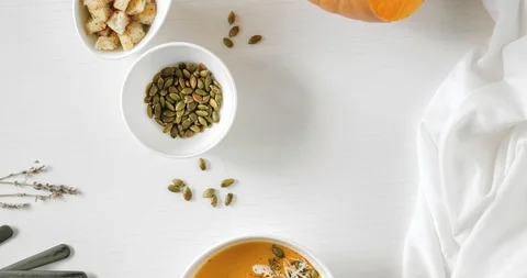Stop motion animation Pumpkin soup, a piece of pumpkin, seeds and crackers. A 4K Stock Footage 128426317