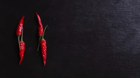 Stop motion animation of red hot peppers writing hot on slate background Stock Footage 125633366