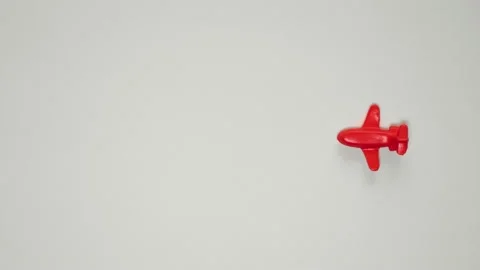 Stop motion animation of the red plastic toy plane flying on a white paper. Stock Footage 131171605
