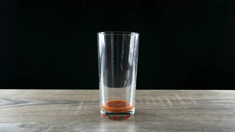 Stop motion animation. Tomato juice is reduced and added in a glass Stockbeeldmateriaal 111565670