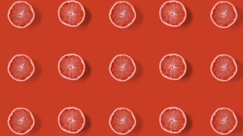 Stop motion animation Top view on grapefruit halves tile on orange background. Stock Footage 135416303