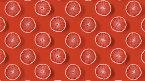 Stop motion animation Top view on grapefruit halves rotating over orange table. Stock Footage 135416310