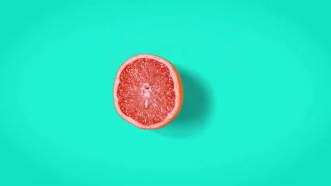Stop motion animation Top view on grapefruit half wiggling on cyan background. Stock Footage 135417383