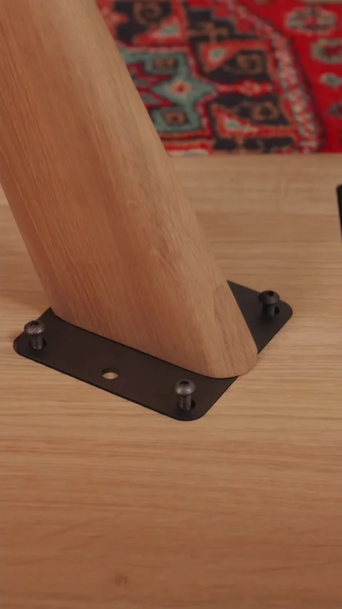 Stop motion animation of wooden table leg screwing into base Stock Footage 346396522