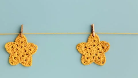 Stop motion animation Yellow crocheted stars moving row on a blue background Stock Footage 254795941