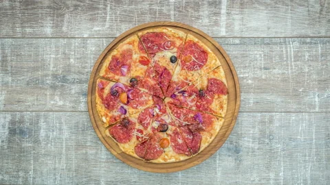Stop motion of appearance of fresh pizza on a wooden table Stock Footage 104858764