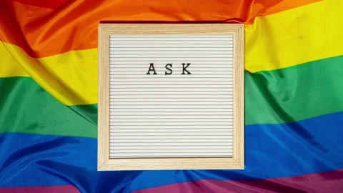 Stop motion of ASK MY PRONOUNS text Neo pronouns concept on Rainbow flag Stock Footage 239495835